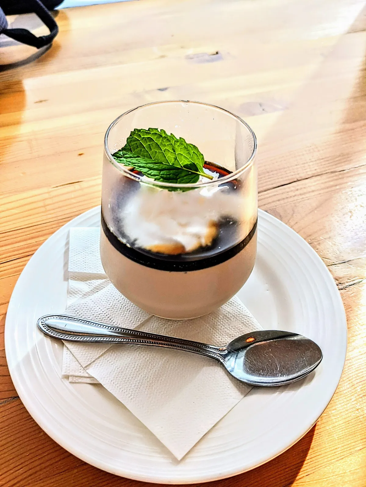 dessert in a glass with a mint leaf and spoon